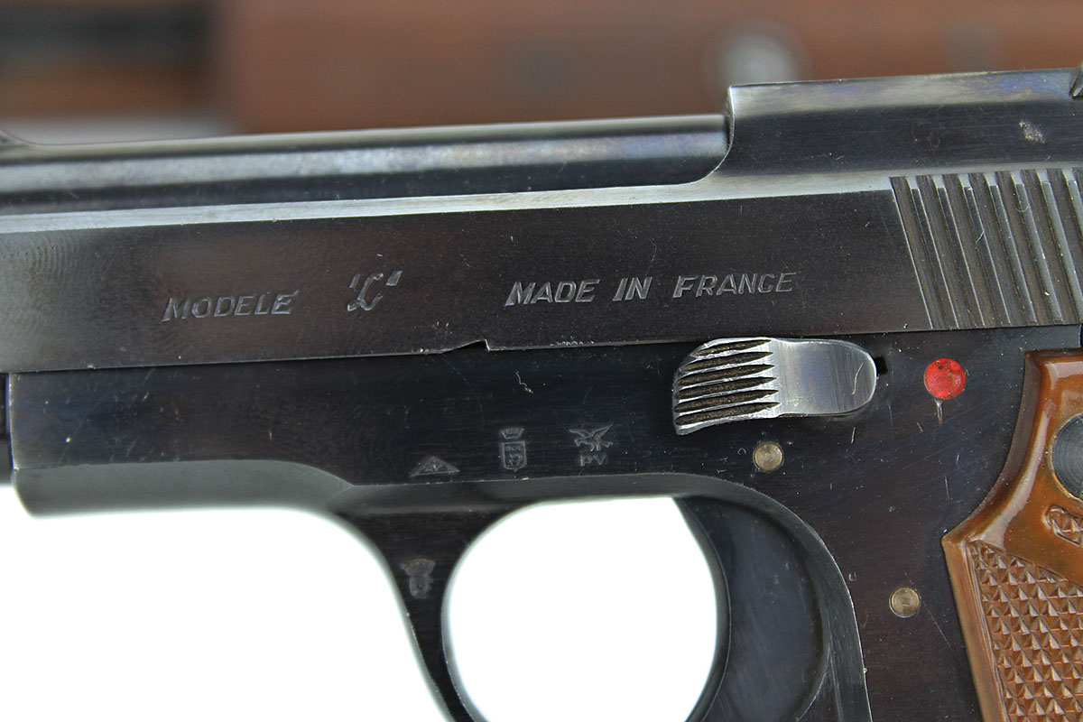 The pistol’s left side bears the model name and several proof/acceptance stamps.
